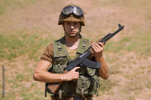 Military, gun and training with portrait of man in nature for war, conflict and patriotism. Army, surveillance and security with person and rifle gear in outdoors for soldier, battlefield and veteran