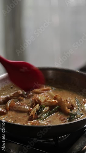 A close-up video of preparing spicy Indian homemade fish curry at home photo