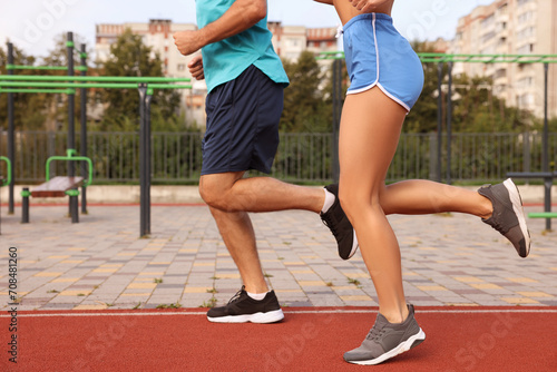 Healthy lifestyle. Sporty couple running at stadium, closeup © New Africa