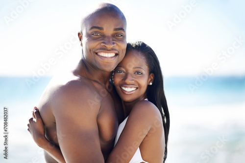 Smile, hugging and portrait of black couple at the beach for valentines day vacation, holiday or adventure. Happy, embracing and African man and woman on a date by the ocean on weekend trip together.