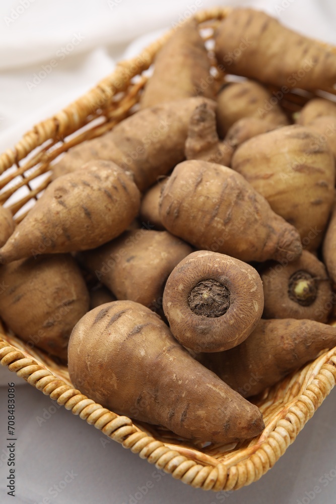 Tubers of turnip rooted chervil in wicker basket on table, closeup Tubers of turnip rooted chervil in wicker basket on table, closeup