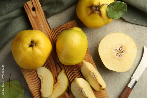 Tasty ripe quince fruits and knife on grey table, flat lay photo