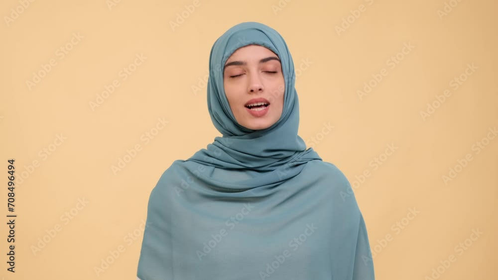 Positive Arab content creator shares vibrant personality against a warm beige background, creating a connection with viewers through engaging conversation, spreading positivity and joy in each frame. Positive Arab content creator shares vibrant personality against a warm beige background, creating a connection with viewers through engaging conversation, spreading positivity and joy in each frame.