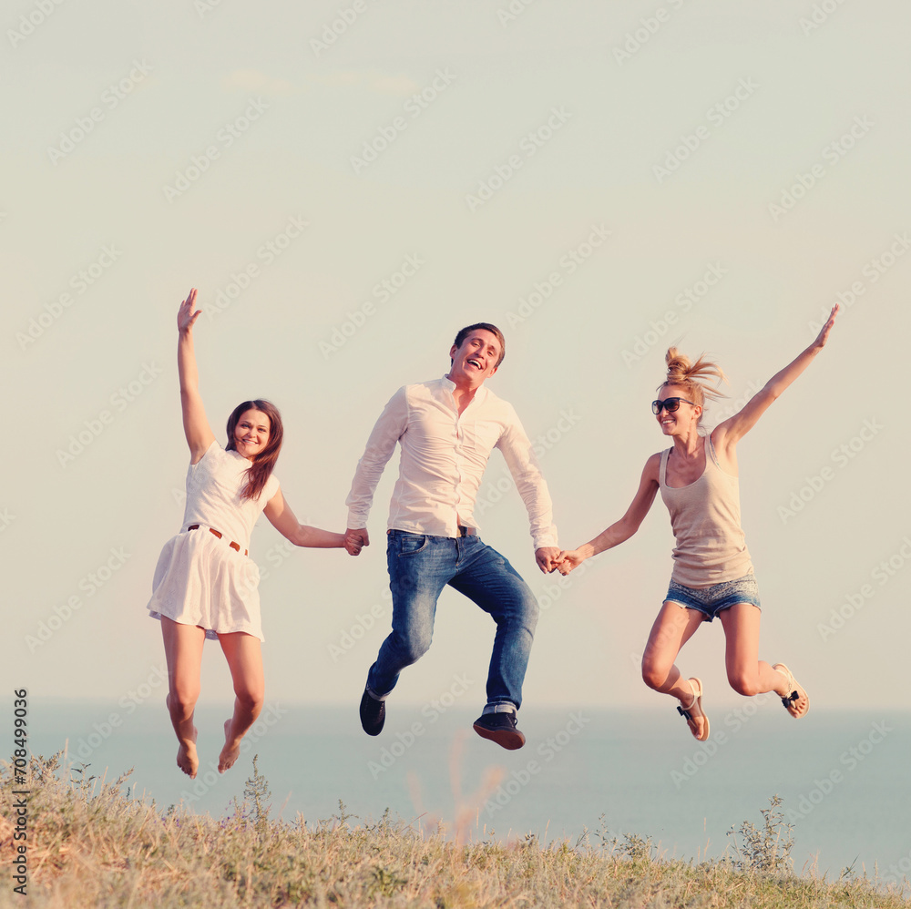 Fototapeta premium Happy friends jumping on the beach