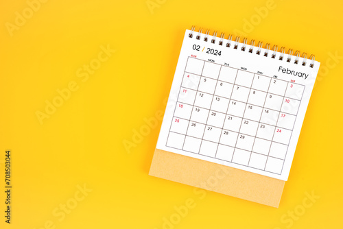 February 2024 desk calendar on yellow color background, position with copy space.