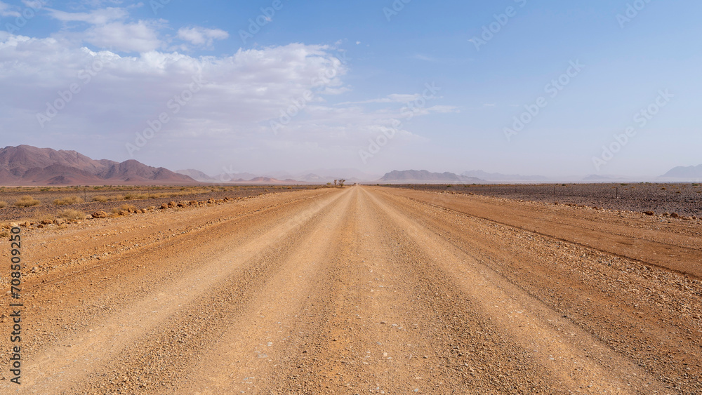 Driving through a gravel road inside Namibia and enjoying the astonishing surrounding scenery