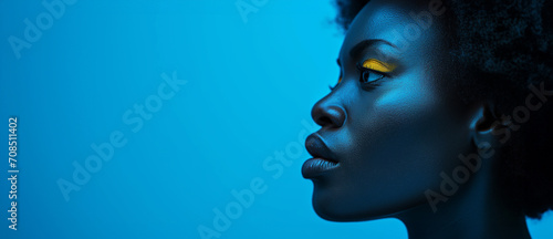 Beautiful African face on bright blue wall background, Concept of beauty, makeup, cosmetics 