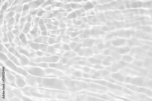 White water with ripples on the surface. Defocus blurred transparent white colored clear calm water surface texture with splashes and bubbles. Water waves with shining pattern texture background.