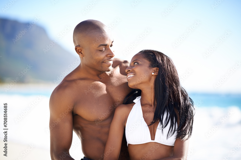 Happy, love and young black couple at the beach for valentines day vacation, holiday or adventure. Smile, romance and African man and woman on a date by the ocean or sea on weekend trip together.