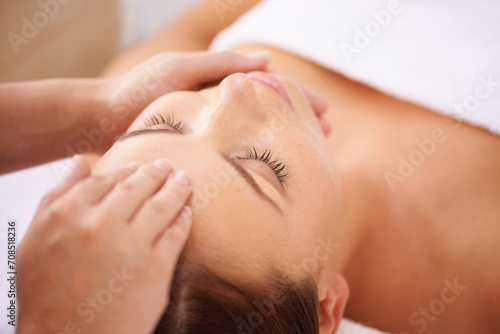 Woman, spa and forehead massage on face for beauty, holistic therapy and healing at cosmetics salon. Calm client relax at wellness resort for facial reiki, acupressure and peaceful skincare treatment