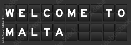 Black color analog flip board with word welcome to malta on gray background