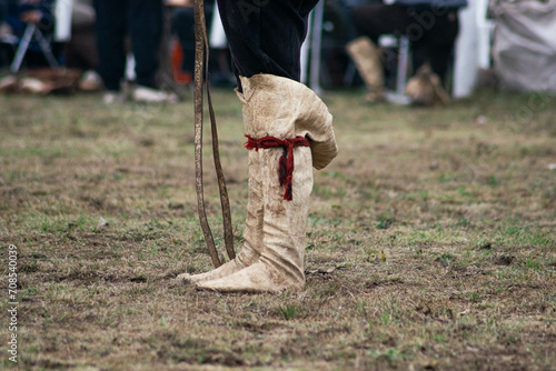 gaucho argentino con sus botas de cuero parado en un campo de domas tradicional photo