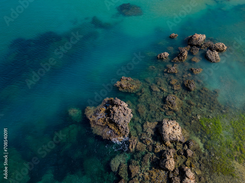 Beautiful sharp rocks formation in turquoise sea in Malta near the beach aerial 