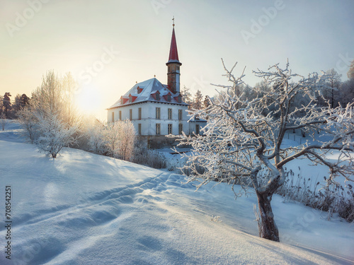 Sunny winter frosty sunset. Evening snowy landscape with old Maltese palace in beautiful natural landscape. Gatchina. Russia. photo