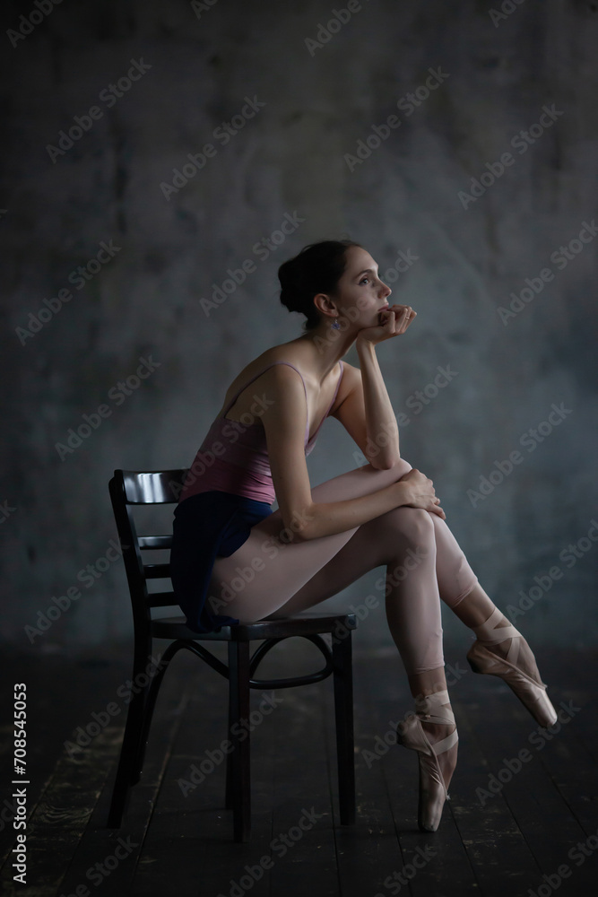 Portrait of a beautiful ballerina sitting on a chair.