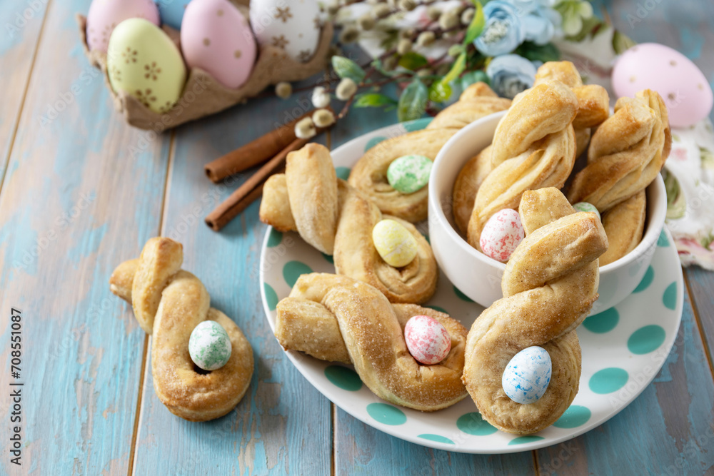 Easter rabbit-shaped buns puff pastry with cinnamon on a wooden blue tabletop. Copy space. Easter rabbit-shaped buns puff pastry with cinnamon on a wooden blue tabletop. Copy space.
