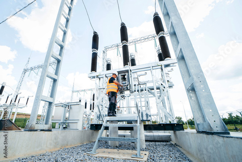 Adult electrical engineer inspect the electrical systems at the equipment control cabinet. Installation of modern electrical station photo