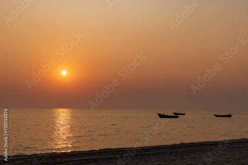 Sunset at Pattaya beach  Thailand  with fisherman ships and sun reflection on sea surface