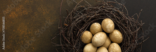 Cosmic Easter eggs in a nest on a brown background  top view  copy space  Easter banner