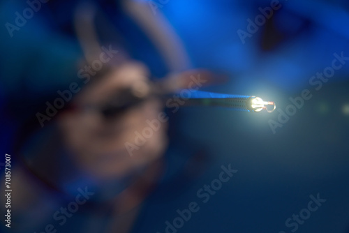 Close up of lighting hysteroscope in hands of blurred male doctor in clinic