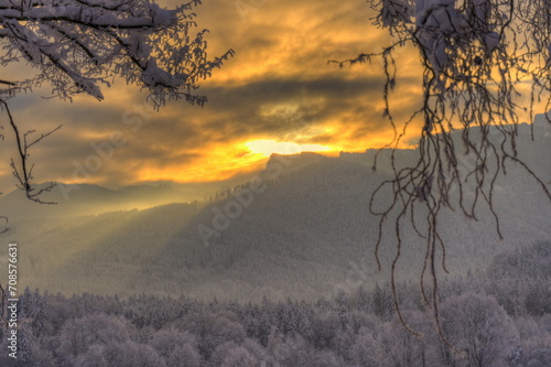 Bewölkter Sonnenaufgang über traumhafter Winterlandschaft photo