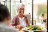 Smiling elderly woman eating a salad