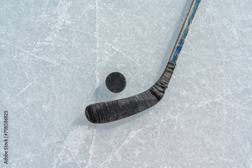 puck and ice hockey stick on the scratches surface abstract background ice arena