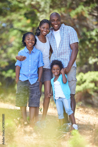 Happy, portrait or black family hiking in forest to relax or bond on holiday vacation together in nature. Children siblings, mother or African father in woods trekking on outdoor adventure with smile © Tasneem H/peopleimages.com