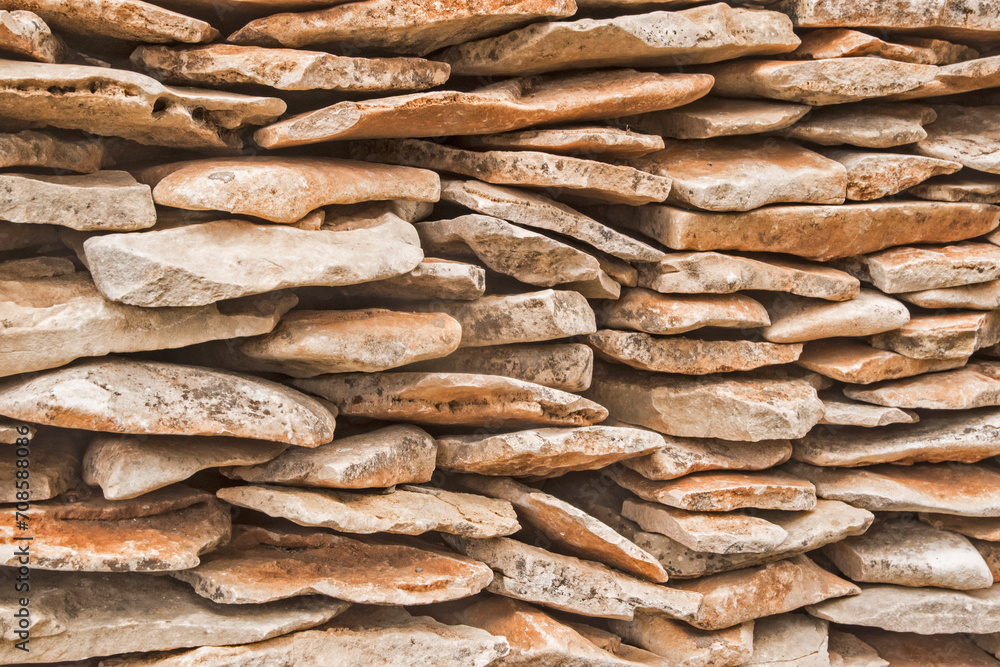 Stone wall made of stone slabs closeup as background Stone wall made of stone slabs closeup as background