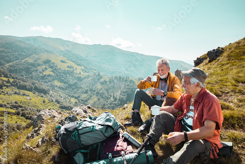 Senior men smiling and resting during mountain hike