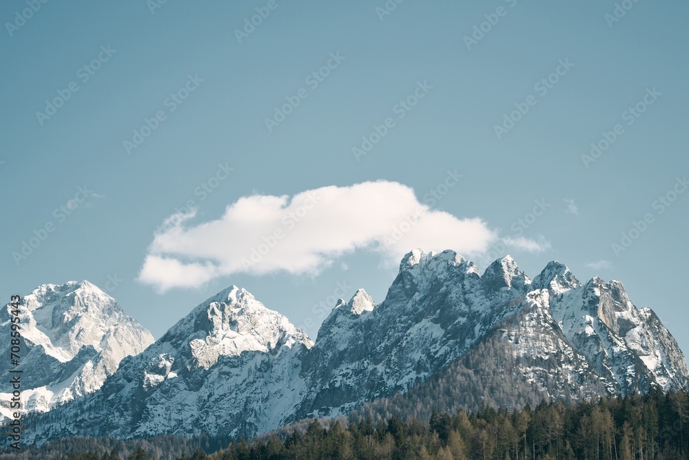 Majestic Dolomites covered with snow and ice in the sunset glow. Trekking and tourism natural background. Nature masterpiece with towering snow-capped peaks and a tranquil forest.