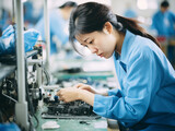 Chinesische Arbeiterin in einer Fabrik, Müde asiatische Frau, Arbeiter führt Reparaturen in einer Elektronikfabrik durch
