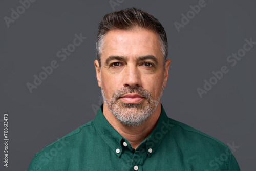 Confident middle aged business man entrepreneur, unsmiling mature professional executive manager, businessman leader investor wearing green shirt isolated on gray, headshot close up portrait. photo