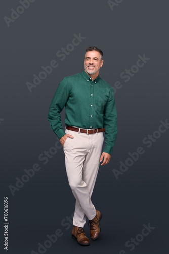 Confident happy elegant middle aged business man entrepreneur, smiling older professional stylish businessman wearing green shirt looking at camera standing isolated on gray, full length vertical. photo