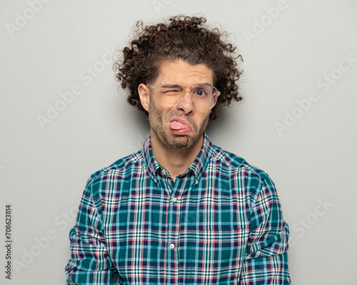 funny casual guy with curly hair and glasses making faces