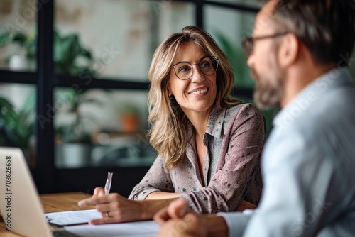 Two business executives discussing financial legal papers in office at meeting. Smiling female lawyer adviser consulting mid aged client at meeting. Mature colleagues doing paperwork, Generative AI