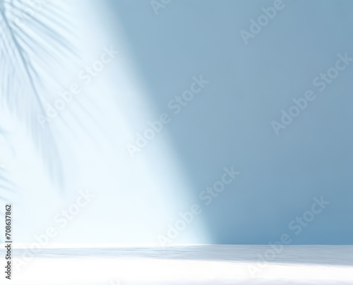 Minimalistic light background with blurred shadow of foliage on light blue wall.