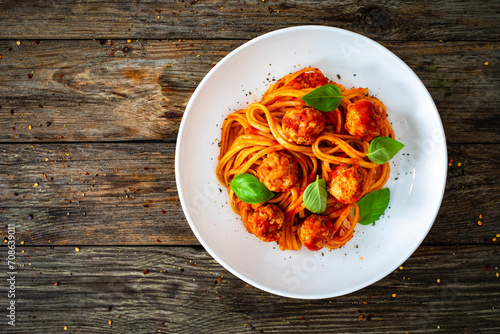 Spaghetti meatballs in bolognese sauce on wooden table photo