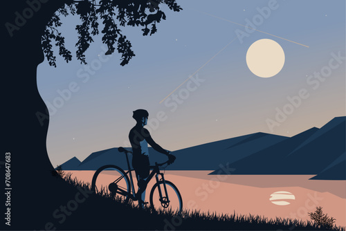 The silhouette of a cyclist looking from the mountains to the lake. Silhouette of a cyclist on the road.