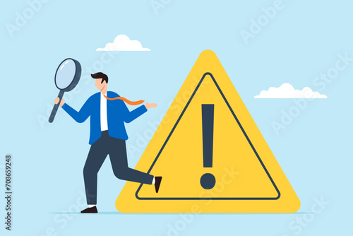 Businessman investigate incident with magnifier and exclamation sign