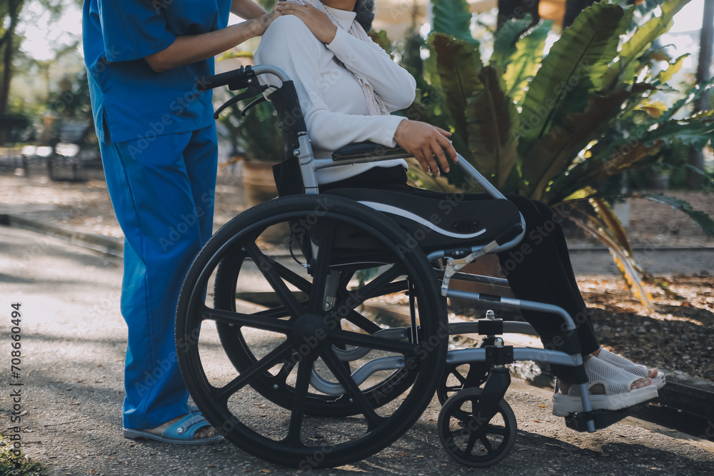 Obraz premium nurse with elderly man in wheelchair at park