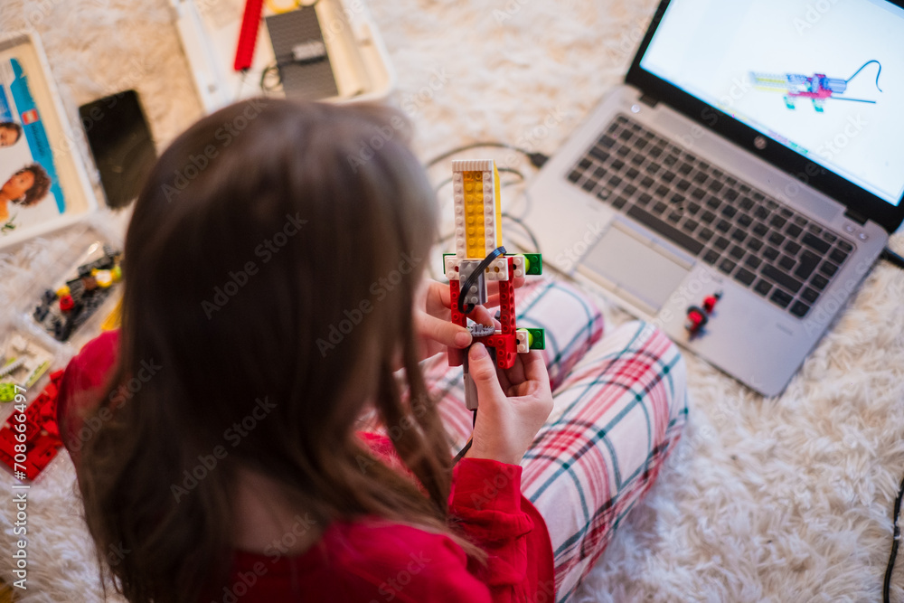 Fototapeta premium Tallinn, Estonia - December 25, 2023: Child building a moving Lego Education WeDo robot at home. Robotics for kids. Educational toys.