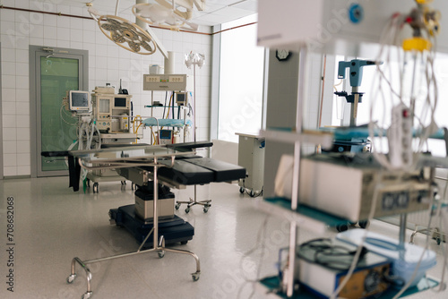 Light interior of modern operating room and equipment in hospital, no people. Medical device for surgeon surgical emergency patient. Light clean surgical theatre with diverse equipment.