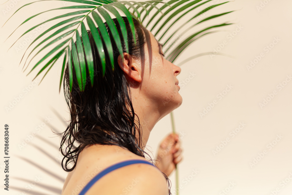 Portrait of a girl in a swimsuit with palm branch.... Portrait of a girl in a swimsuit with palm branch....