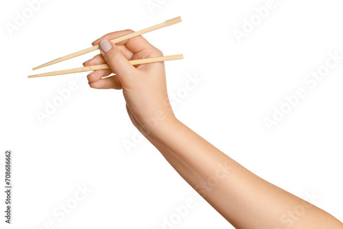 A woman's hand holds wooden chopsticks for sushi or rolls on a blank background. photo