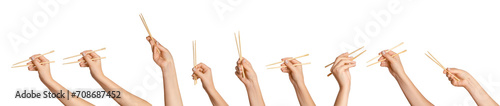 Photos A set of female hands holding wooden chopsticks for sushi or rolls on a blank background
