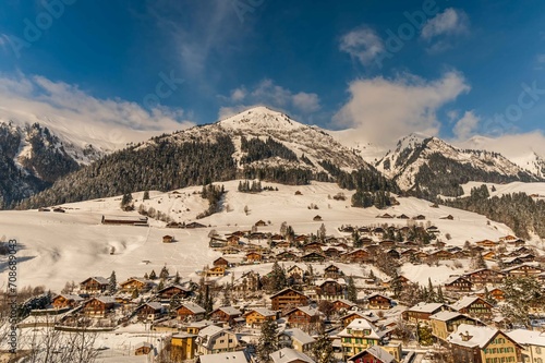 Winter landscape of Swiss village in Switzerland. Mountain, sky and Swiss chalet.