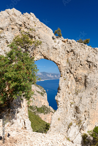 Panoramic view of the Orosei gulf seen through a natural rock arch from the trail leading to the bay Cala Mariolu, in east Sardinia