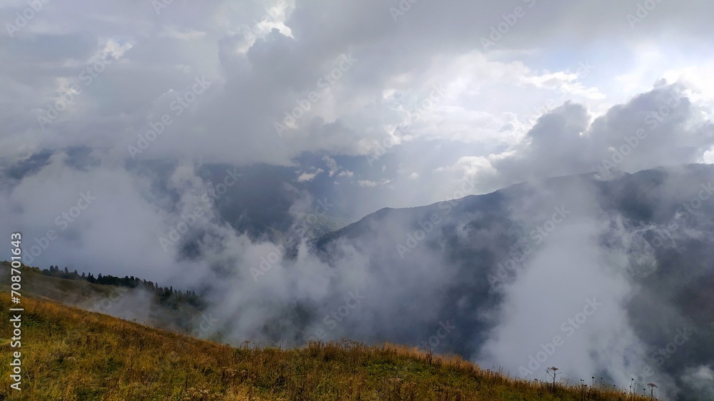 Clouds of fog rise above the mountains, the magic of nature, the beauty of the mountains, natural landscape