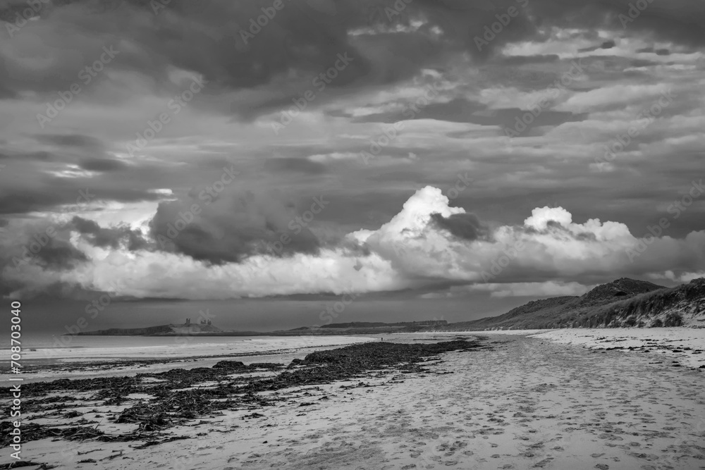Beautiful dramatic  black and white unusual Winter landscape of snow on Embleton Bay beach in Northumberland England